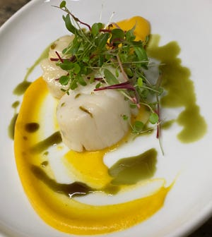 Poached Viking Village scallops with carrot coulis from Perona Farms.